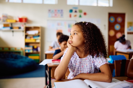 Elementary schoolgirl sitting at desk